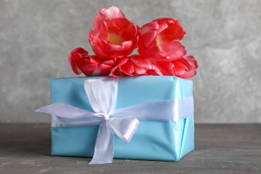 Güzel lale çiçekleri ve gri arka planda hediye kutusu. Anneler Günü kutlaması