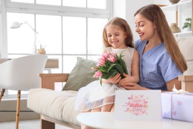 Anneler Günü 'nde annesini salonda lalelerle karşılayan tatlı küçük bir kız.