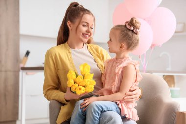 Anneler Günü 'nde annesini sarı lalelerle karşılayan tatlı küçük bir kız.