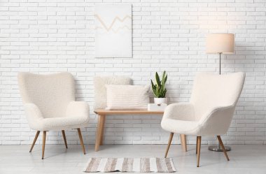 Işık odasında lamba, bank ve yastıklı beyaz koltuklar.