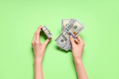 Yeşil arka planda dolar banknotları olan eller