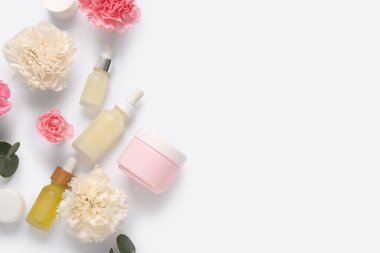 Farklı kozmetik ürünleri ve açık arkaplanda güzel çiçekler