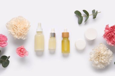 Farklı kozmetik ürünleri ve açık arkaplanda güzel çiçekler