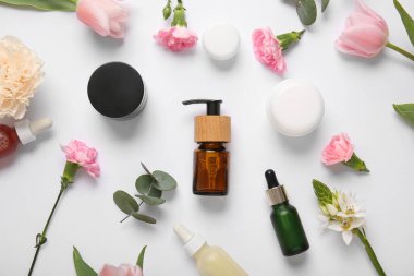 Farklı kozmetik ürünleri ve açık arkaplanda güzel çiçekler