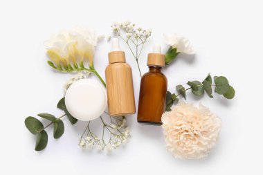 Farklı kozmetik ürünleri ve açık arkaplanda güzel çiçekler