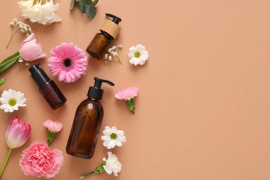 Farklı kozmetik ürünleri ve kahverengi arka planda güzel çiçekler.
