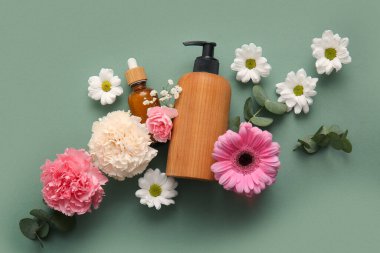 Farklı kozmetik ürünleri ve yeşil arka planda güzel çiçekler.