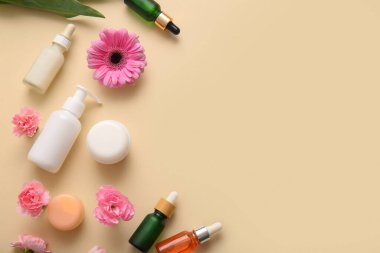 Bej arka planda farklı kozmetik ürünleri ve güzel çiçekler