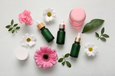 Farklı kozmetik ürünleri ve açık arkaplanda güzel çiçekler