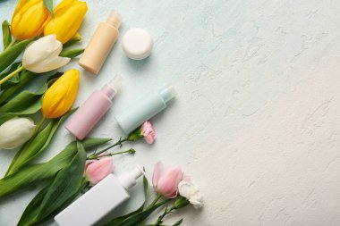 Farklı kozmetik ürünleri ve açık arkaplanda güzel çiçekler