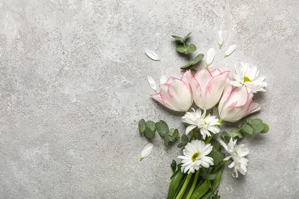 Papatya çiçekli güzel laleler ve gri arka planda okaliptüs dalları. Anneler Günü kutlaması