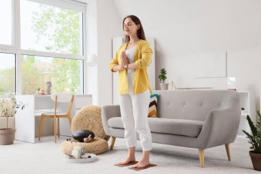 Evde Sadhu tahtasında meditasyon yapan genç bir kadın.