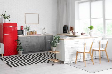 Havalı buzdolabı ve mutfak duvarının yanındaki tezgahlar.