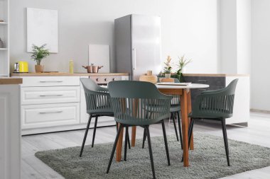 Buzdolabı, tezgah ve yemek masası olan modern mutfağın şık iç tasarımı.