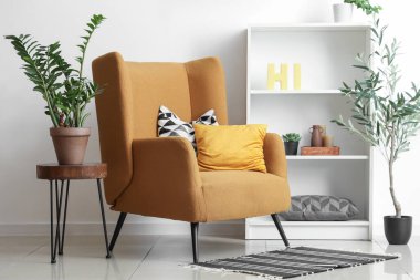 Rahat koltuğu, kahve masası ve zeytin ağacı olan şık bir oturma odası.