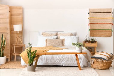 Yatağı, çiçekleri ve çiçekleri olan hafif yatak odasının içi.