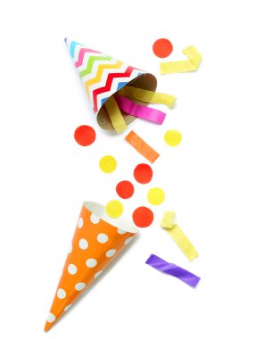 Beyaz arka planda konfeti olan parti şapkaları