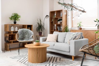 Rahat kanepesi, koltuğu ve masası olan modern oturma odası.