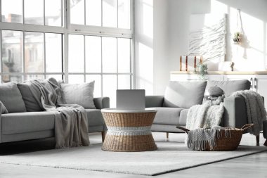 Modern oturma odasının içinde disko topu, gri kanepeler ve sehpanın üzerinde dizüstü bilgisayar.