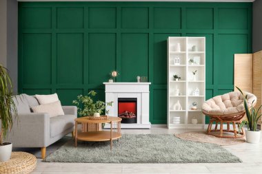 Interior of modern living room with fireplace, grey sofa and armchair