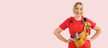 Pembe arkaplanda alet kemeri ve metin için yeri olan kadın işçi