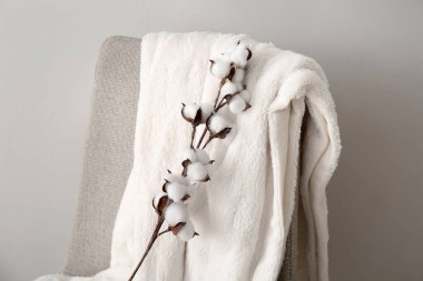 Beyaz duvarın yanında battaniyeli pamuk filizi