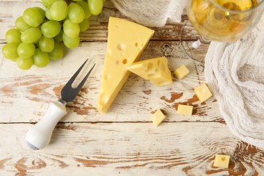 Hafif ahşap arka planda lezzetli İsviçre peyniri ve üzümleri