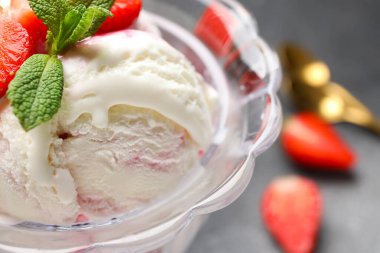 Bir kase vanilyalı dondurma, çilekli ve naneli, yakın plan.