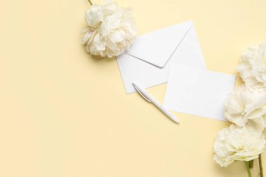 Renk arkaplan üzerinde boş kart, kalem ve güzel şakayık çiçekleri olan kompozisyon