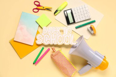 Kağıt metin ile kırtasiye ve megafon açık sarı arka planda okula geri dönsün