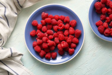 Açık mavi arkaplanda taze ahududu tabakları