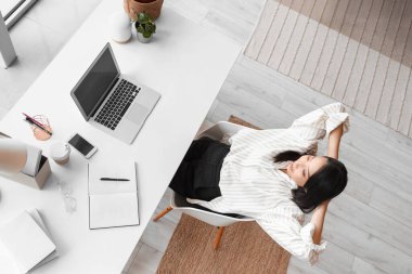 Genç Asyalı kadın merkez ofiste dinleniyor.