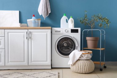 Çamaşır odasının içi çamaşır makinesi ve temizlik malzemesiyle dolu.