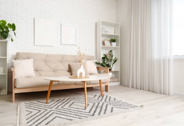 Rahat kanepesi, çiçekleri ve beyaz mobilyaları olan aydınlık oturma odasının içinde.