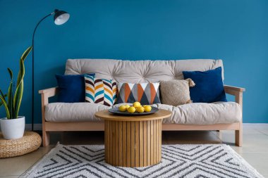 Rahat kanepe, standart lamba ve kahve masasında limonlar olan şık bir oturma odası.