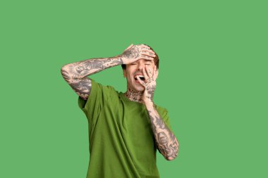 Yeşil arka planda gülen genç adam