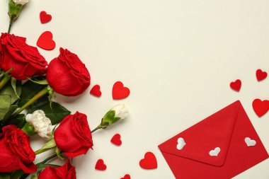 Karanfilli kırmızı güller, beyaz arka planda zarf ve kalpler. Sevgililer Günü konsepti