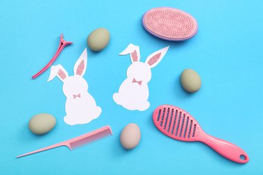 Mavi arka planda Paskalya yumurtası ve kağıt tavşanlı kuaför aksesuarları
