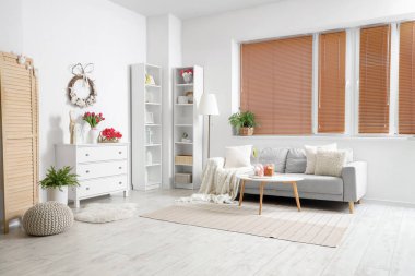 Paskalya için dekore edilmiş oturma odasının içinde kanepe, raf üniteleri ve tuvalet var.