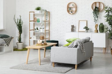 Kanepesi, ahşap masası ve yumuşak yastıkları olan modern oturma odası.