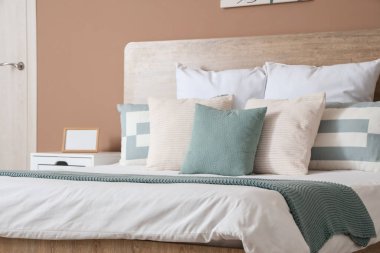 Yatak odasındaki büyük yatakta yumuşak yastıklar.