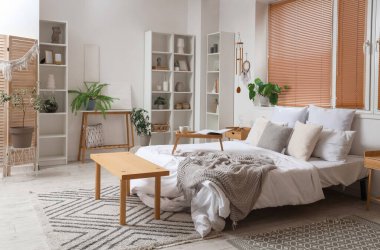 Hafif yatak odasının içinde rüzgar çanı, düş kapanı ve bitkiler var.