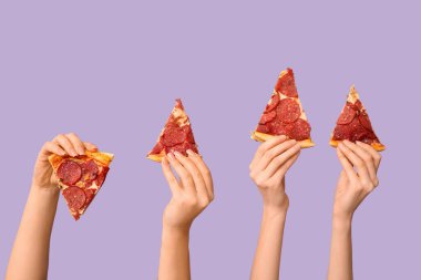 Leylak arka planında pizza dilimleri tutan bir sürü el.