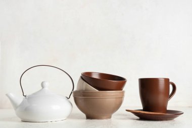 Beyaz arkaplanda kahverengi, temiz sofra takımı ve çaydanlık yığını