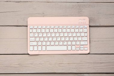 Ahşap zemin üzerinde modern pembe bilgisayar klavyesi
