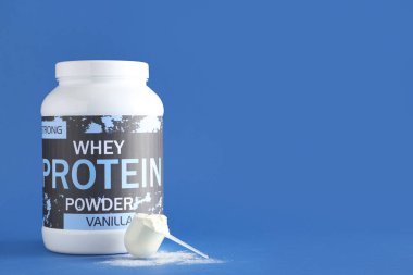 Bottle of protein powder and scoop on color background