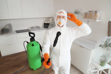 Mutfaktaki masada dezenfektan silindirli bir erkek işçi.