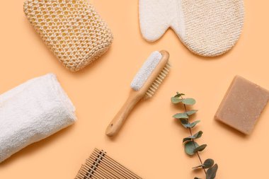 Masaj eldivenli kompozisyon, sünger taşı ve bej arka planda fırça