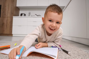 Mutfakta yere keçeli kalem çizen komik çocuk, yakın plan.