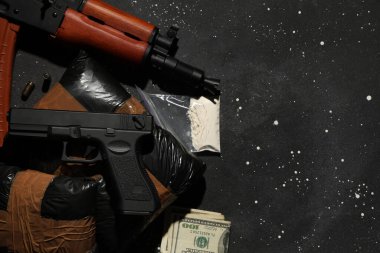 Karanlık arka planda silahlı uyuşturucu paketleri
